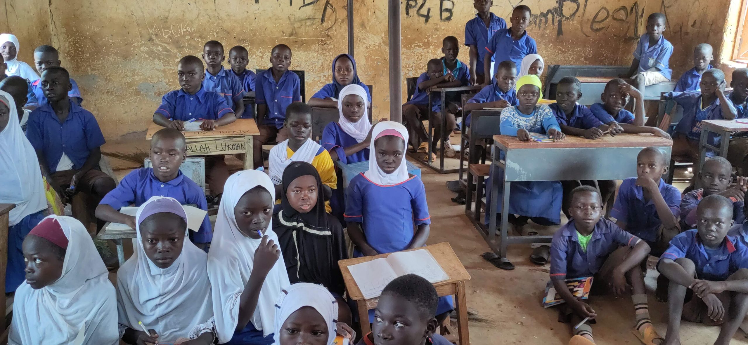 Kinder sitzen auf dem Boden, weil es zu wenig Möbel gibt