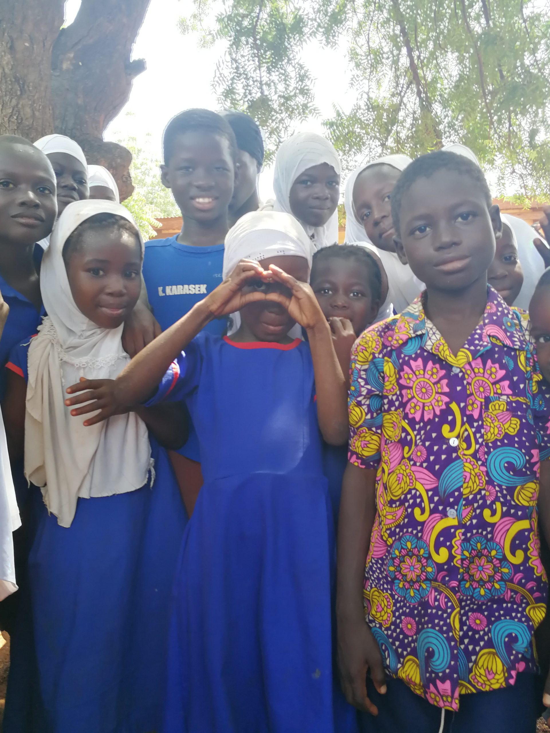 Kinder formen ihre Finger zum Herz